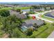 Aerial view of a home with a screened in pool and patio area surrounded by lush greenery in a residential area at 1525 Gants Cir, Kissimmee, FL 34744