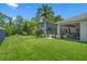 Beautiful backyard with a screened-in porch, manicured lawn, and tropical landscaping at 1525 Gants Cir, Kissimmee, FL 34744