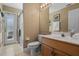 Bright bathroom features tile floors, glass shower, white toilet, and a wood vanity with ample lighting at 1525 Gants Cir, Kissimmee, FL 34744