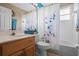 Bathroom features blue trim, a shower with blue floral curtain, and wood vanity cabinet at 1525 Gants Cir, Kissimmee, FL 34744