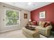 Guest bedroom with a large window, red accent wall, and simple decor at 1525 Gants Cir, Kissimmee, FL 34744