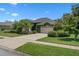 Charming one-story home features a well-manicured lawn, colorful flowers, and lush green landscaping at 1525 Gants Cir, Kissimmee, FL 34744