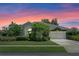 Charming exterior view of the home with manicured lawn and colorful sunset at 1525 Gants Cir, Kissimmee, FL 34744
