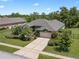 Aerial view of a well-maintained home with a manicured lawn, mature trees, and lush landscaping at 1525 Gants Cir, Kissimmee, FL 34744