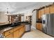 Open-concept kitchen featuring granite countertops, wooden cabinets, and stainless steel appliances at 1525 Gants Cir, Kissimmee, FL 34744