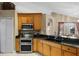 Kitchen featuring granite countertops, wooden cabinetry, and stainless steel double oven at 1525 Gants Cir, Kissimmee, FL 34744