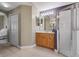 Bright bathroom features a glass shower, wood vanity with sink, and a linen closet for storage at 1525 Gants Cir, Kissimmee, FL 34744