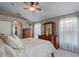 Bright main bedroom features a ceiling fan, wood furniture, and natural light from windows with sheer curtains at 1525 Gants Cir, Kissimmee, FL 34744