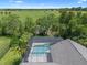 Aerial view of a screened pool, surrounded by landscaping and a large green field at 1525 Gants Cir, Kissimmee, FL 34744
