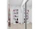 Organized walk-in closet featuring shelving with decor and mirrored sliding doors at 1710 Thor Ave, Apopka, FL 32703