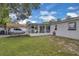 Exterior rear view of the home with a spacious backyard, carport, and a screened in patio at 1710 Thor Ave, Apopka, FL 32703