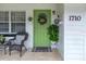 Close-up shot of the home's inviting front entrance, plants, and a green door with decor at 1710 Thor Ave, Apopka, FL 32703