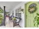Inviting front porch featuring comfortable seating, decor, and a vibrant green door with wreath at 1710 Thor Ave, Apopka, FL 32703