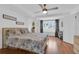 Bright main bedroom featuring a patterned bedspread, wood laminate floors, and large window with curtains at 1710 Thor Ave, Apopka, FL 32703