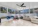 Bright sunroom features neutral tile flooring, modern ceiling fan, and lots of windows for natural light at 1710 Thor Ave, Apopka, FL 32703