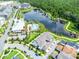 Community aerial view showcasing amenities including a lake, pool, and clubhouse, all set amongst lush landscaping at 1855 Treasure Cv, Kissimmee, FL 34747