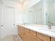 Bright bathroom featuring double sinks, wooden cabinets, and walk in shower at 1855 Treasure Cv, Kissimmee, FL 34747