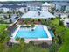 Aerial shot of the neighborhood clubhouse with a large pool, patio, and palm trees for a resort-style living experience at 1855 Treasure Cv, Kissimmee, FL 34747