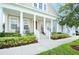 Charming covered front porch with white columns, rocking chairs, and manicured landscaping at 1855 Treasure Cv, Kissimmee, FL 34747