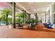 Covered outdoor patio area with comfortable seating, palm trees, and views of the community pool and clubhouse at 1855 Treasure Cv, Kissimmee, FL 34747