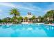 A stunning community pool area featuring clear blue water and a modern clubhouse against a bright blue sky at 1855 Treasure Cv, Kissimmee, FL 34747