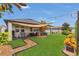 Spacious backyard features a covered patio, lush lawn, string lights and manicured landscaping for outdoor enjoyment at 1864 Castleton Dr, St Cloud, FL 34771