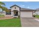 Charming one-story home featuring a two-car garage, lush landscaping, and inviting front entrance with covered porch at 1864 Castleton Dr, St Cloud, FL 34771