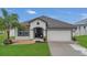 Charming single-story home featuring a two-car garage, well-maintained lawn and landscaping at 1864 Castleton Dr, St Cloud, FL 34771