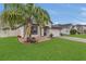 Beautifully landscaped front yard with a vibrant palm tree and well-maintained lawn creating a welcoming curb appeal at 1864 Castleton Dr, St Cloud, FL 34771