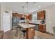 Well-lit kitchen with wood cabinets, stainless steel appliances, and a kitchen island with seating and pendant lights at 1864 Castleton Dr, St Cloud, FL 34771