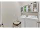 Functional laundry room with a modern washer and dryer, with storage cabinets for organization at 1864 Castleton Dr, St Cloud, FL 34771