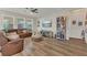 Inviting living room with hardwood floors, ceiling fan, ample natural light, and cozy sectional sofa at 1864 Castleton Dr, St Cloud, FL 34771