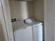 Compact laundry closet with a white, front-loading washing machine and a matching dryer at 2030 Cascades Blvd # 204, Kissimmee, FL 34741