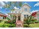 Charming two-story home with a brick walkway and beautiful red flowers, creating a welcoming entrance at 205 N Village St, Celebration, FL 34747