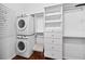 Functional laundry room with a stackable washer and dryer, built-in shelving, and ample storage space for organization at 205 N Village St, Celebration, FL 34747