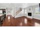 Open-concept living room with a fireplace, hardwood floors, and a staircase, connecting the living spaces seamlessly at 205 N Village St, Celebration, FL 34747
