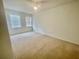 Bright bedroom features neutral carpet, ceiling fan, and two sunny windows at 2243 Seven Oaks Dr, St Cloud, FL 34772