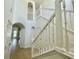 Spacious view of the white banister staircase and foyer with natural light at 2243 Seven Oaks Dr, St Cloud, FL 34772