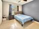 Bedroom showcasing a large window for natural lighting, dark accent wall, and neutral-colored tile floor at 2444 Oak Mill Dr, Kissimmee, FL 34744