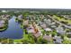 An aerial view shows the property near the lake with mature trees in a friendly neighborhood at 2612 Keswick Ct, Kissimmee, FL 34744