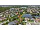 An aerial view highlighting the home's location within a lush, tree-filled neighborhood and pond at 2612 Keswick Ct, Kissimmee, FL 34744