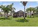 Spacious backyard with palm trees and screened lanai for outdoor entertaining at 2612 Keswick Ct, Kissimmee, FL 34744