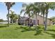Lush backyard features a screened patio, palm trees, and verdant lawn at 2612 Keswick Ct, Kissimmee, FL 34744