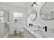 Contemporary bathroom featuring double sinks, a window, and a glass shower at 2612 Keswick Ct, Kissimmee, FL 34744
