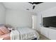 Cozy bedroom featuring a TV, ceiling fan, and soft, comfortable bedding at 2612 Keswick Ct, Kissimmee, FL 34744