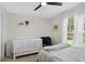 Bright bedroom with a crib, soft natural light, and cozy seating area at 2612 Keswick Ct, Kissimmee, FL 34744