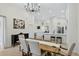 Bright dining area features wood table, chandelier and flows into an open kitchen with white cabinetry at 2612 Keswick Ct, Kissimmee, FL 34744