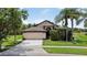 Attractive home with a tidy front lawn, mature shade trees, and a spacious two-car garage at 2612 Keswick Ct, Kissimmee, FL 34744