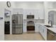 Modern kitchen with stainless steel appliances, white cabinetry, and tile flooring at 2612 Keswick Ct, Kissimmee, FL 34744