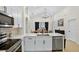 Modern kitchen with stainless steel appliances, white cabinetry and an island overlooking the dining area at 2612 Keswick Ct, Kissimmee, FL 34744
